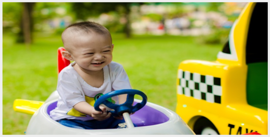 Baby riding toy car in play area