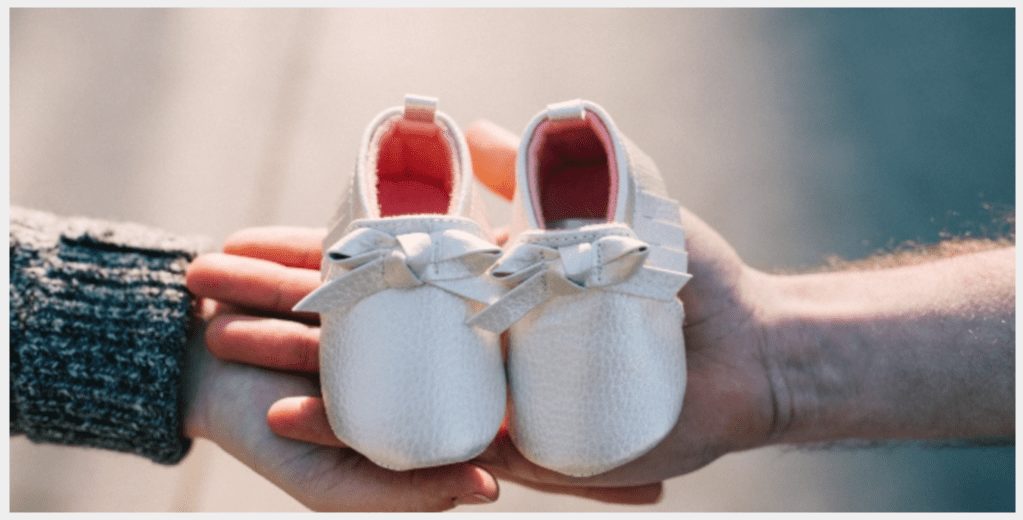 Hands holding baby shoes